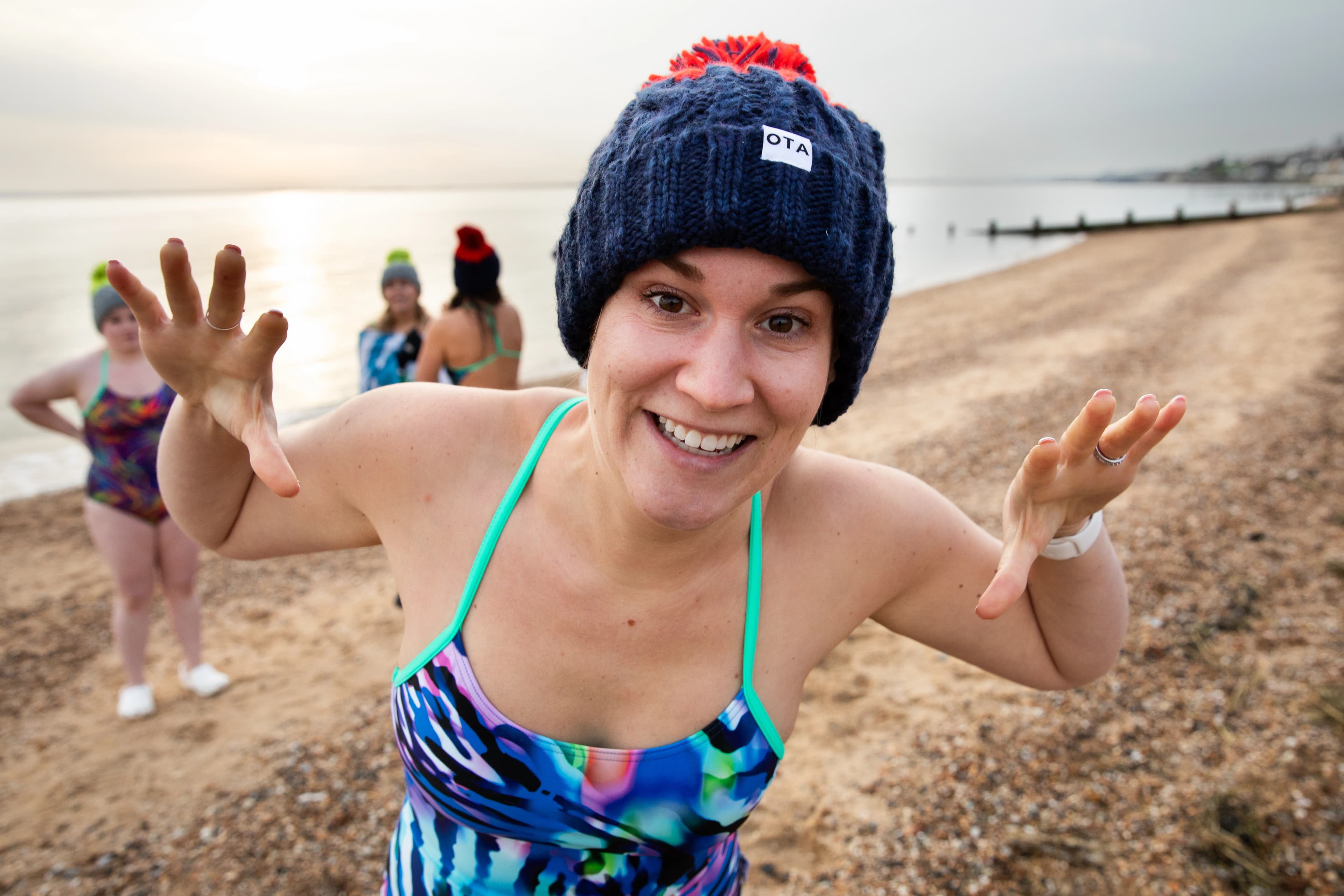 A playful swimmer in colourful swimwear on the shore