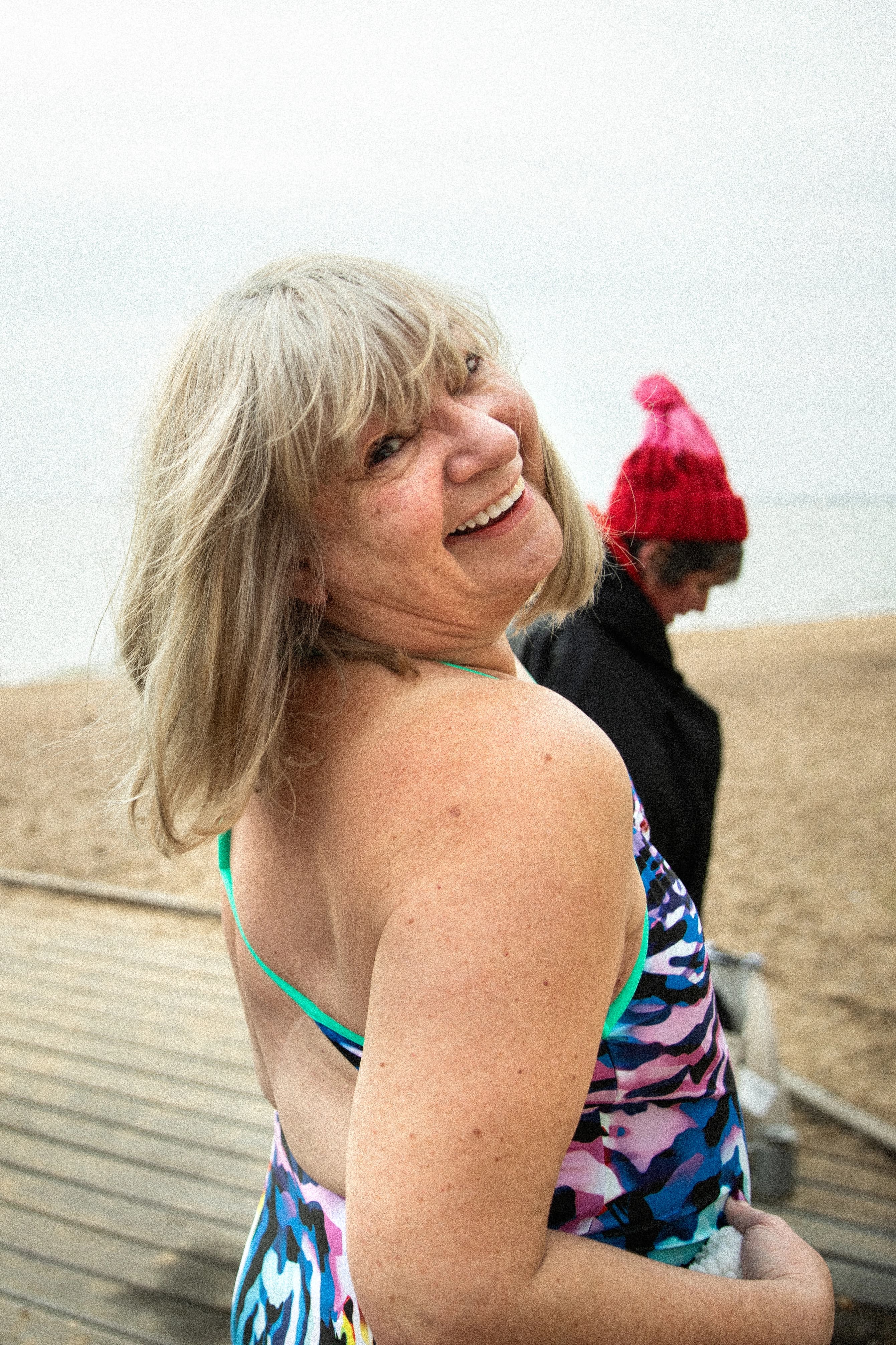A smiling Own The Adventure swimmer in colourful swimwear